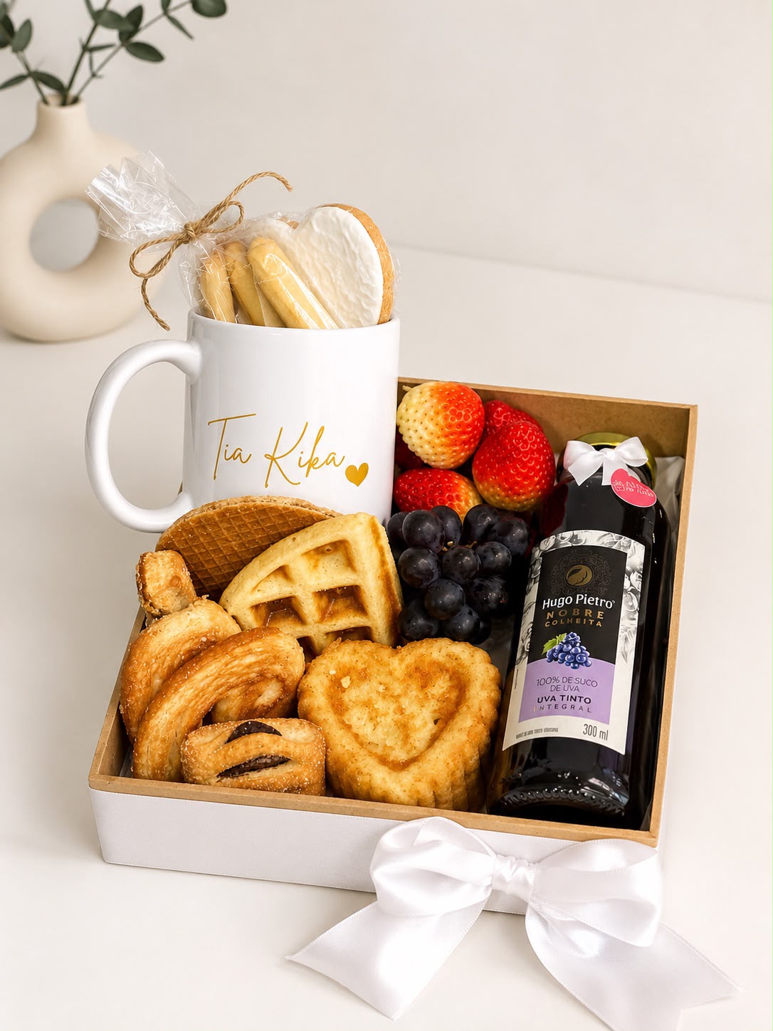 01 Biscoito Decorado 01 Xícara personali 01 Biscoito Treccine 01 Bolinho Simples formato coração  01 Suco de Uva 01 Waffle  02 Biscoito folhado Italiano  01 Strudet 01 Biscoito Holandês 01 Sachê de biscoito crocante  Morangos Uvas